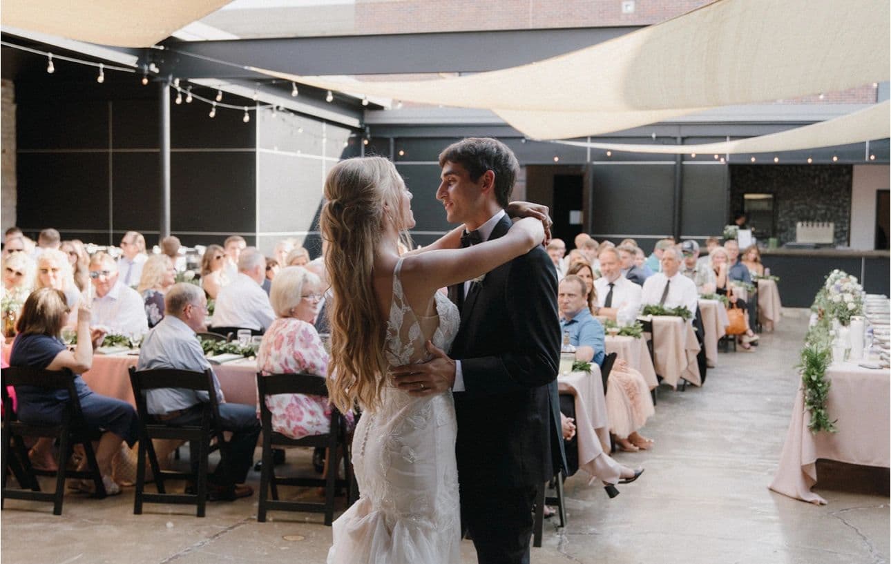 A couple's first dance in the courtyard at Venue 324, under string lights